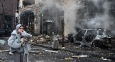 A woman and her dog walk on street in Kyiv after a Russian missile has destroyed the center of the city.
