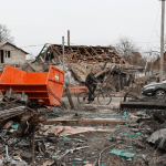 A man in Kherson Ukraine rides a bicycle through wreckage from Russian bombs